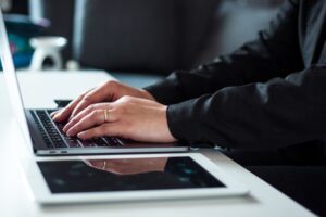professional typing on laptop home office