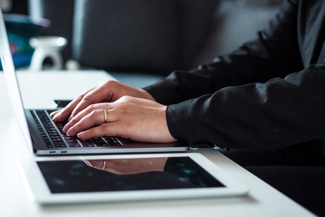 professional typing on laptop home office