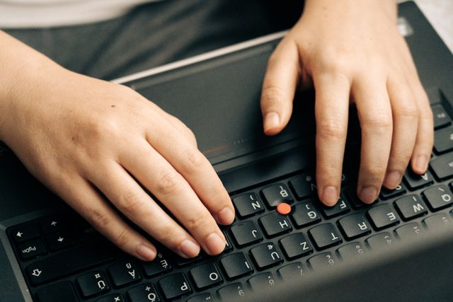close up hands typing keyboard laptop