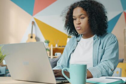 adult student studying laptop home office desk