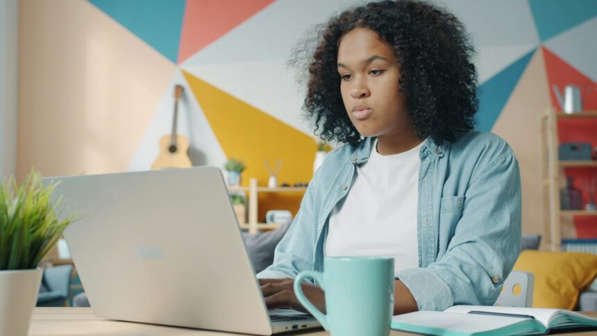 adult student studying laptop home office desk