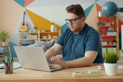 adult studying laptop desk home office