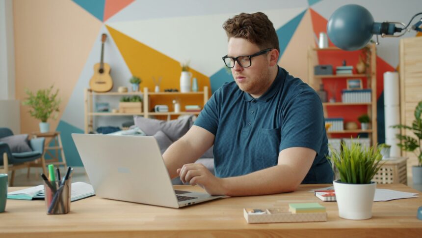 adult studying laptop desk home office